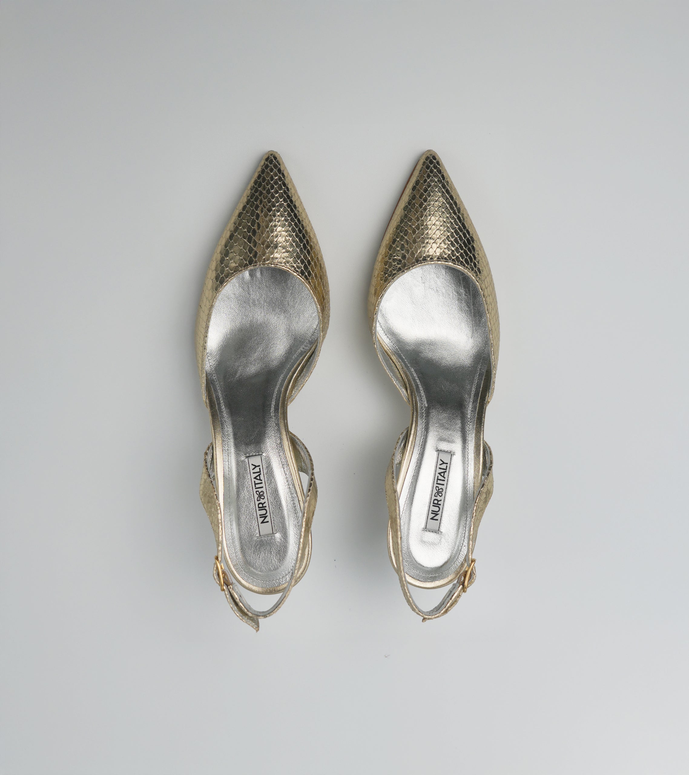 Pair of gold high-heeled shoes on a light gray background #color_venezia gold