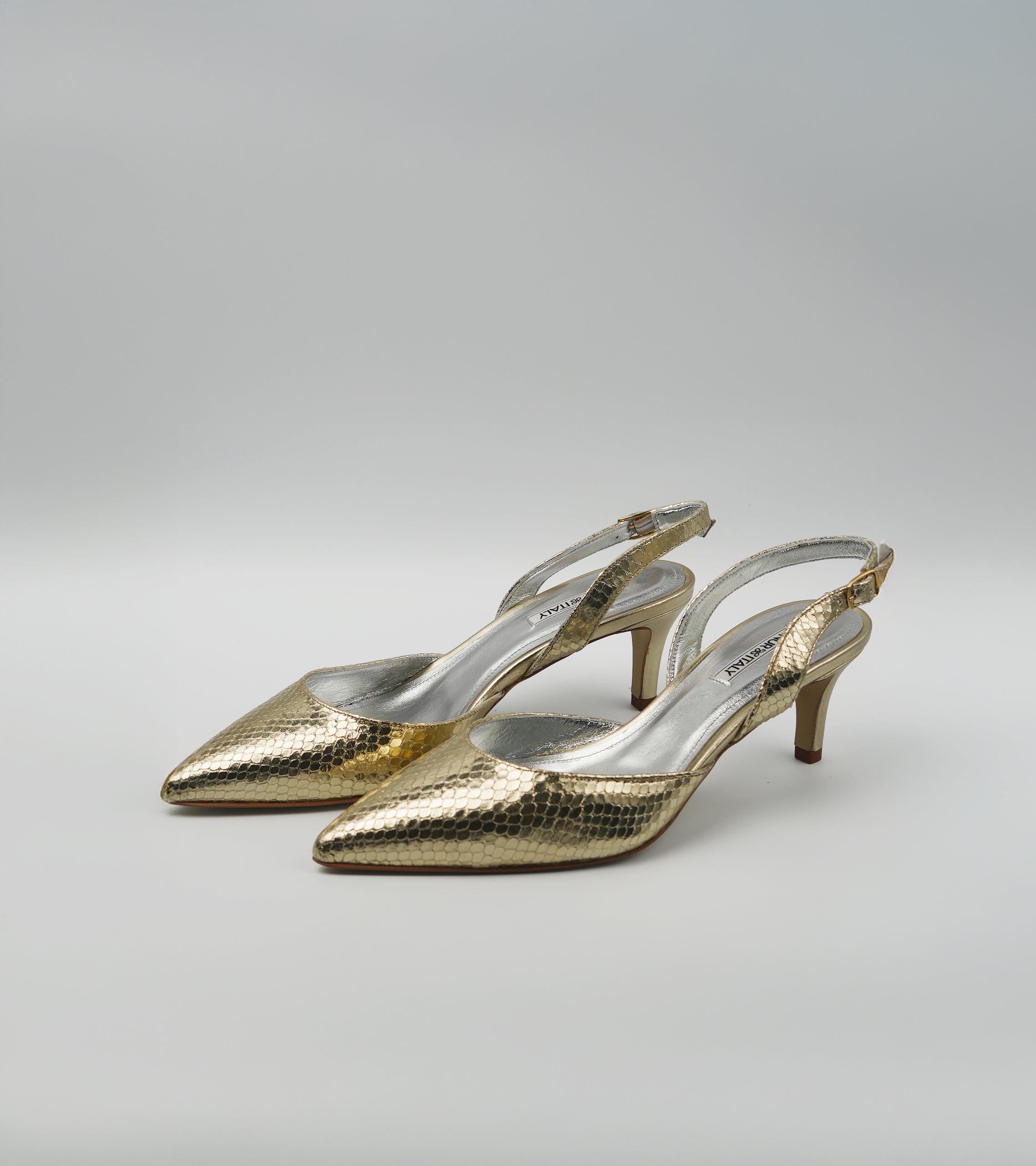 Pair of gold high-heeled shoes on a light gray background #color_venezia gold