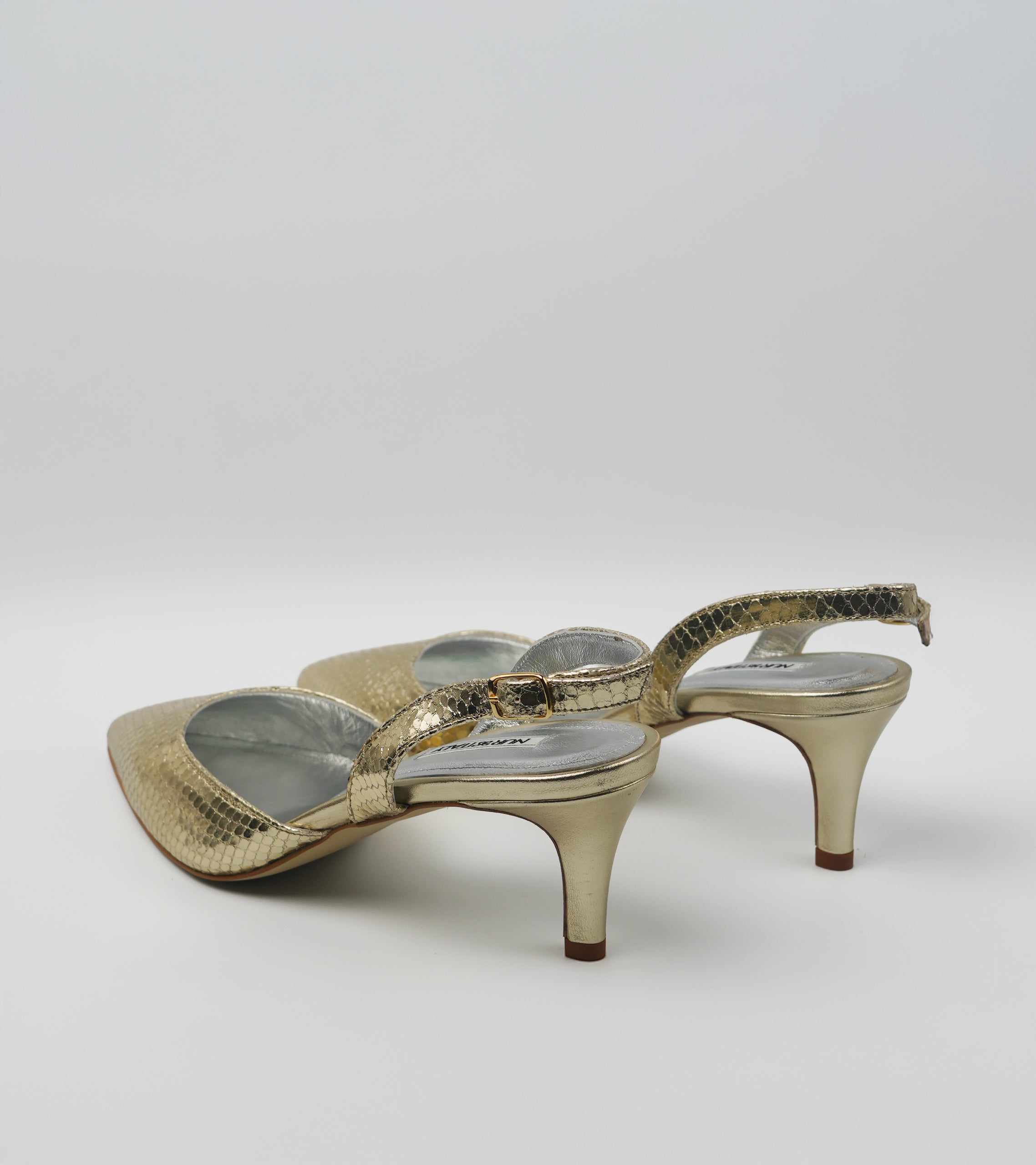 Pair of gold high-heeled shoes on a white background #color_venezia gold