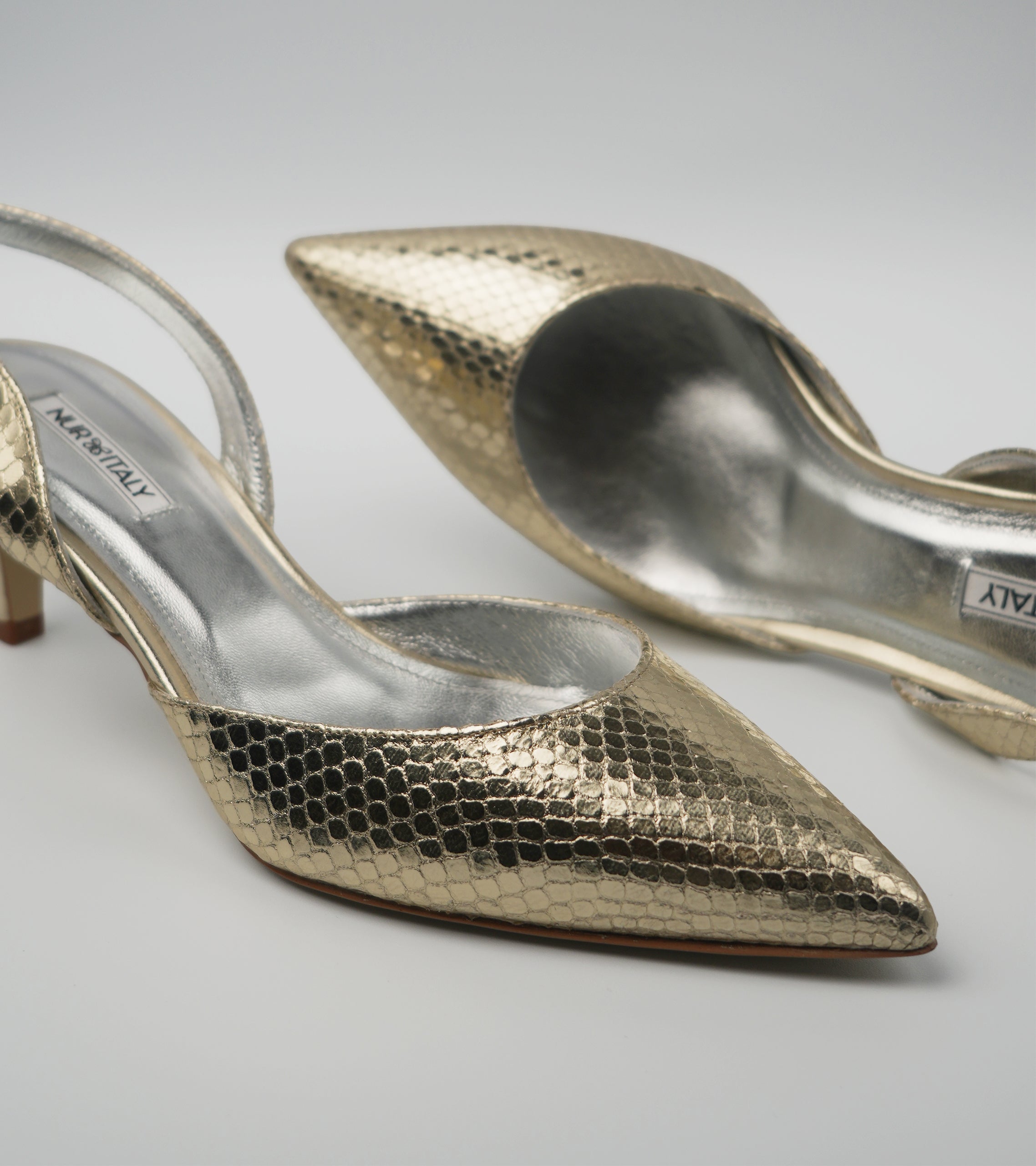 Gold high-heeled shoes with a textured pattern on a light gray background #color_venezia gold
