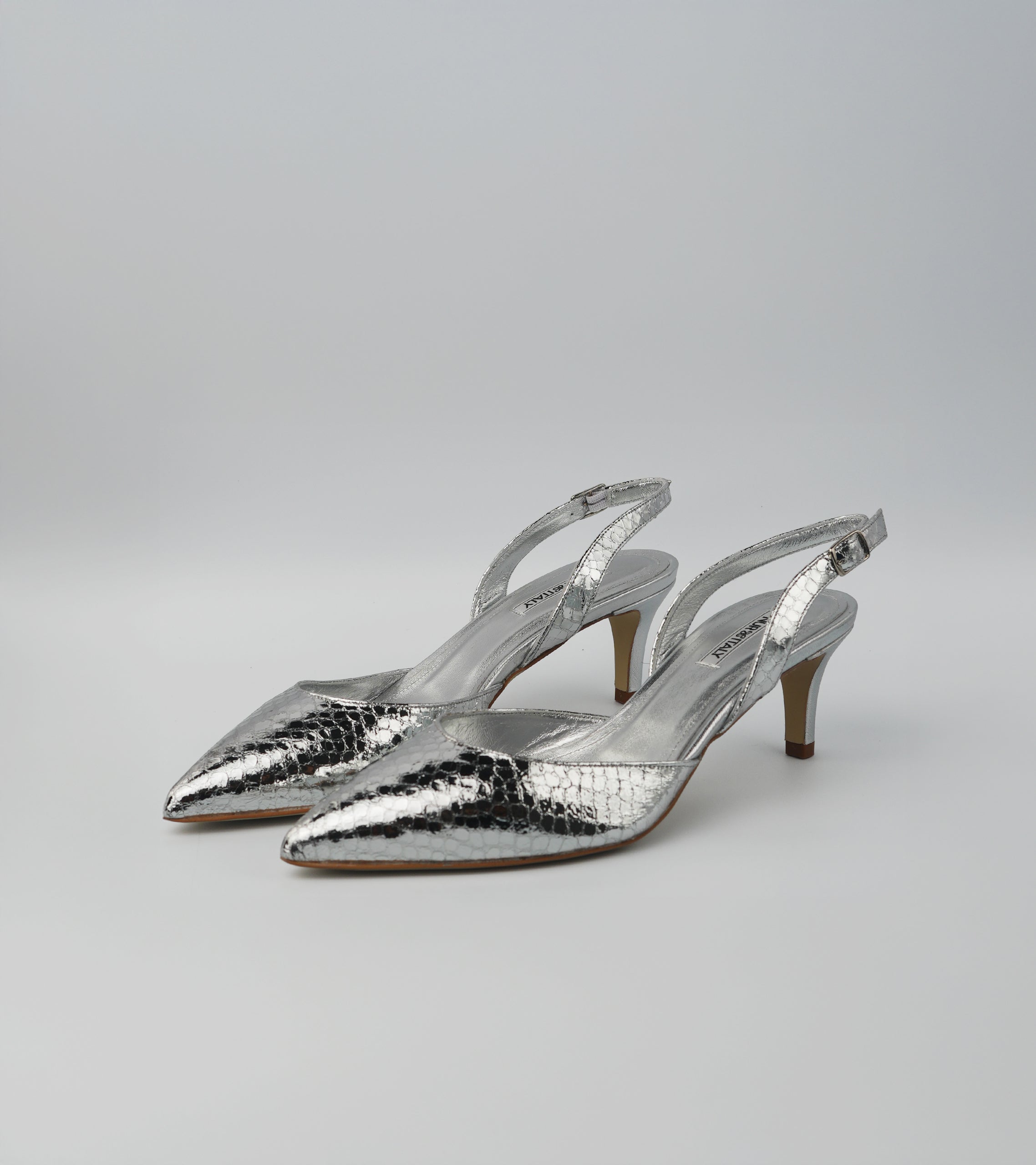 Pair of silver high-heeled shoes on a light gray background #color_napoli silver