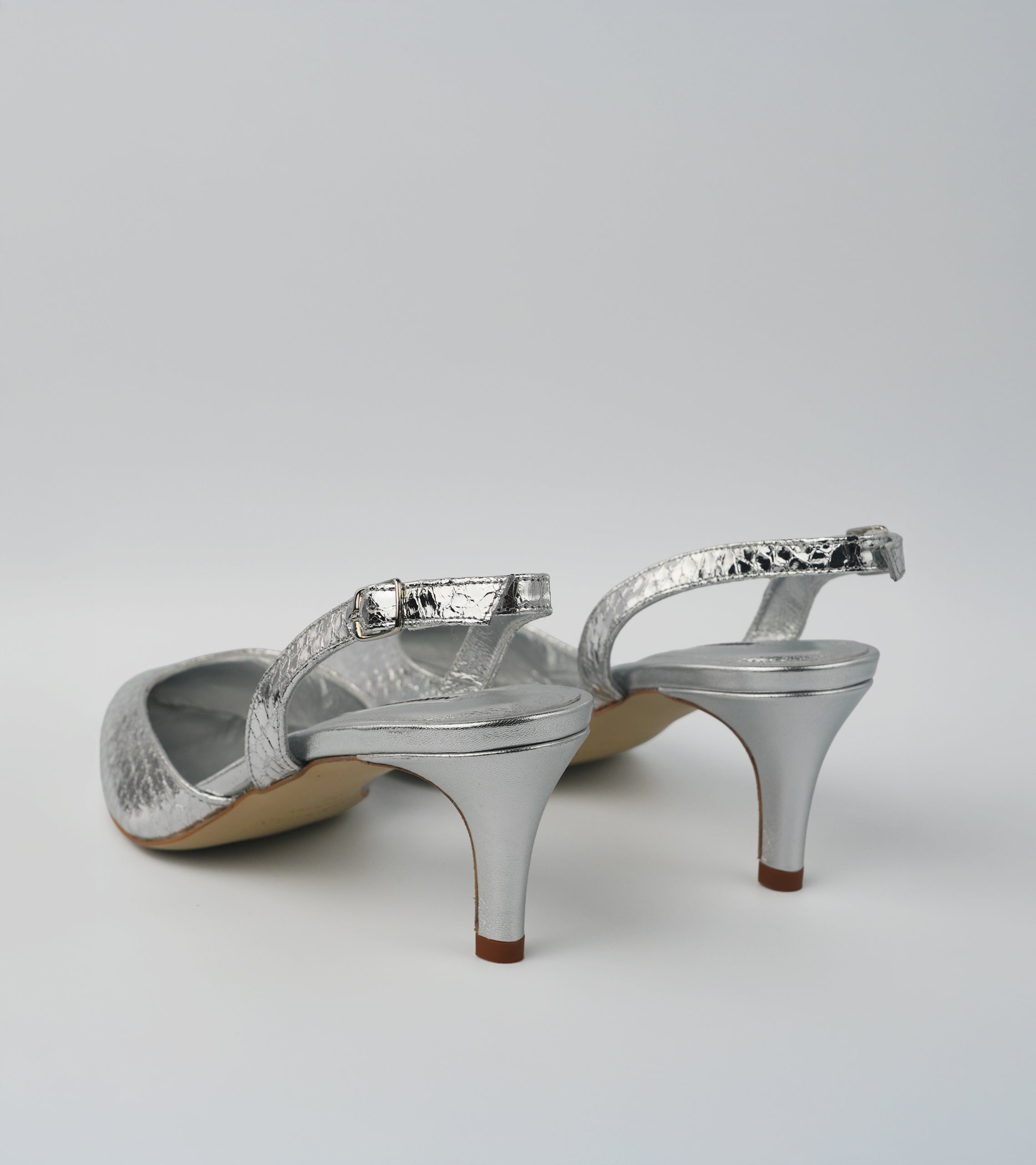 Silver high-heeled shoes on a white background #color_napoli silver