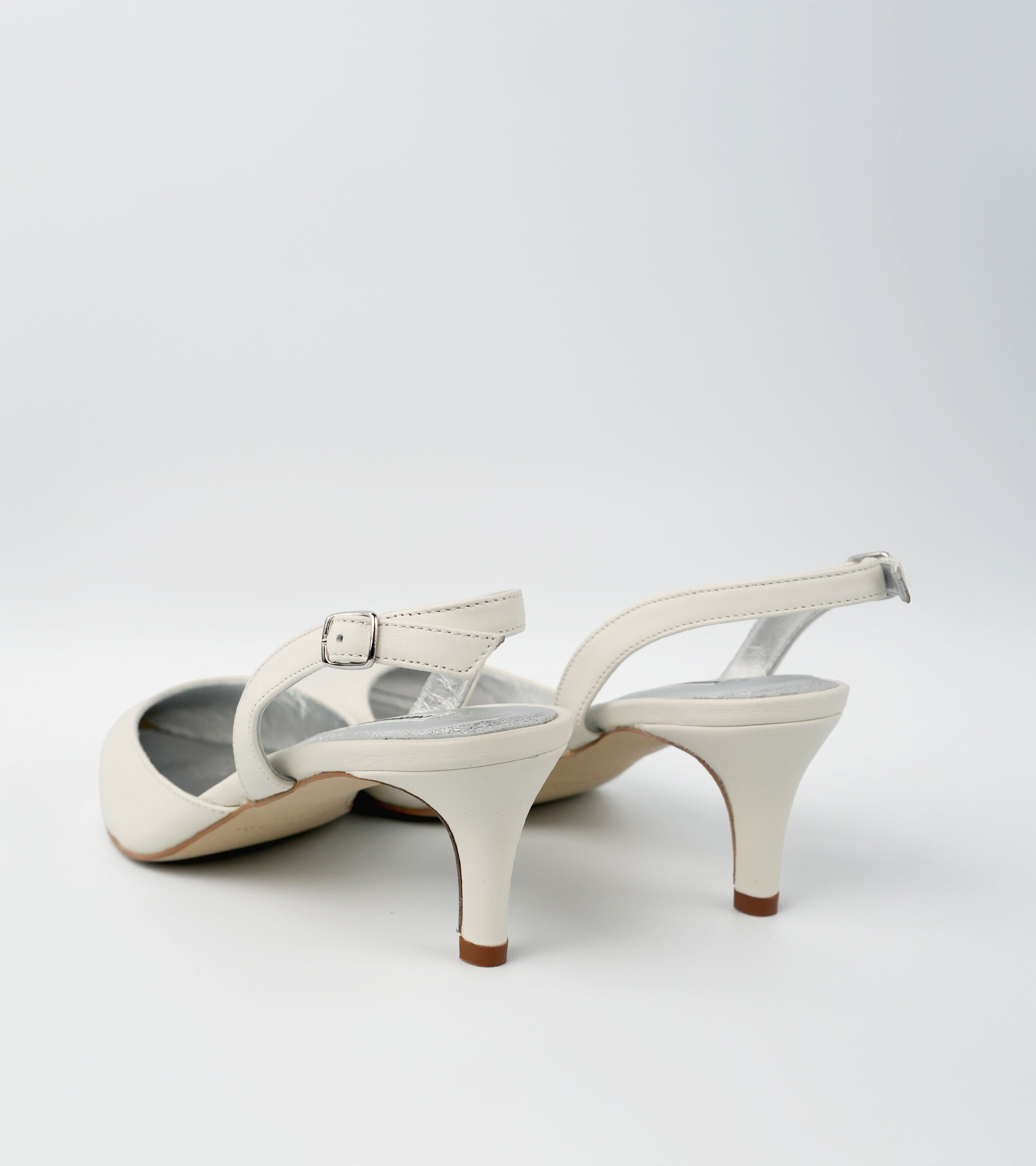 Pair of white high-heeled shoes on a light gray background #color_amalfi white