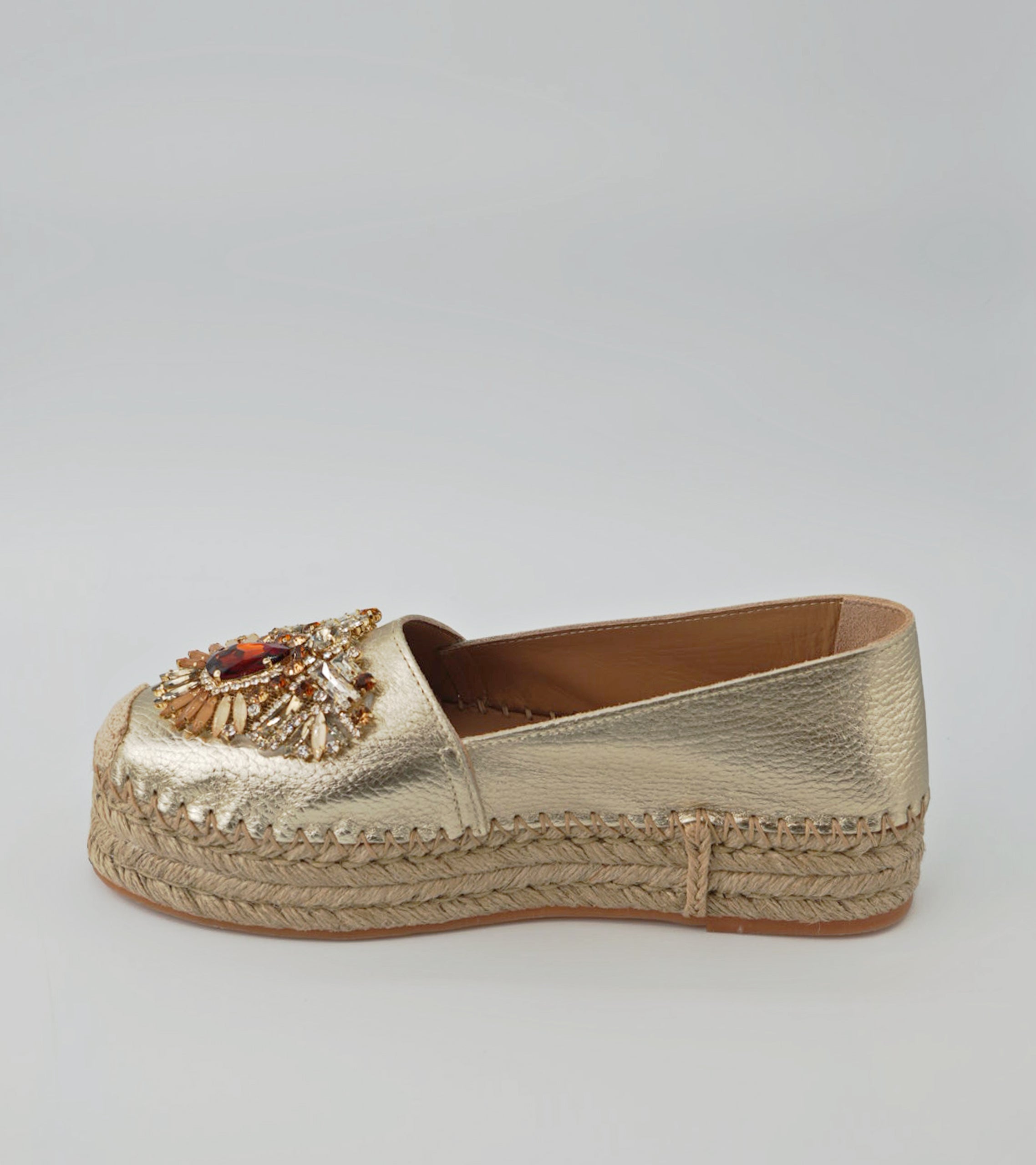 Gold espadrille shoe with embellishments on a light gray background #color_venezia gold