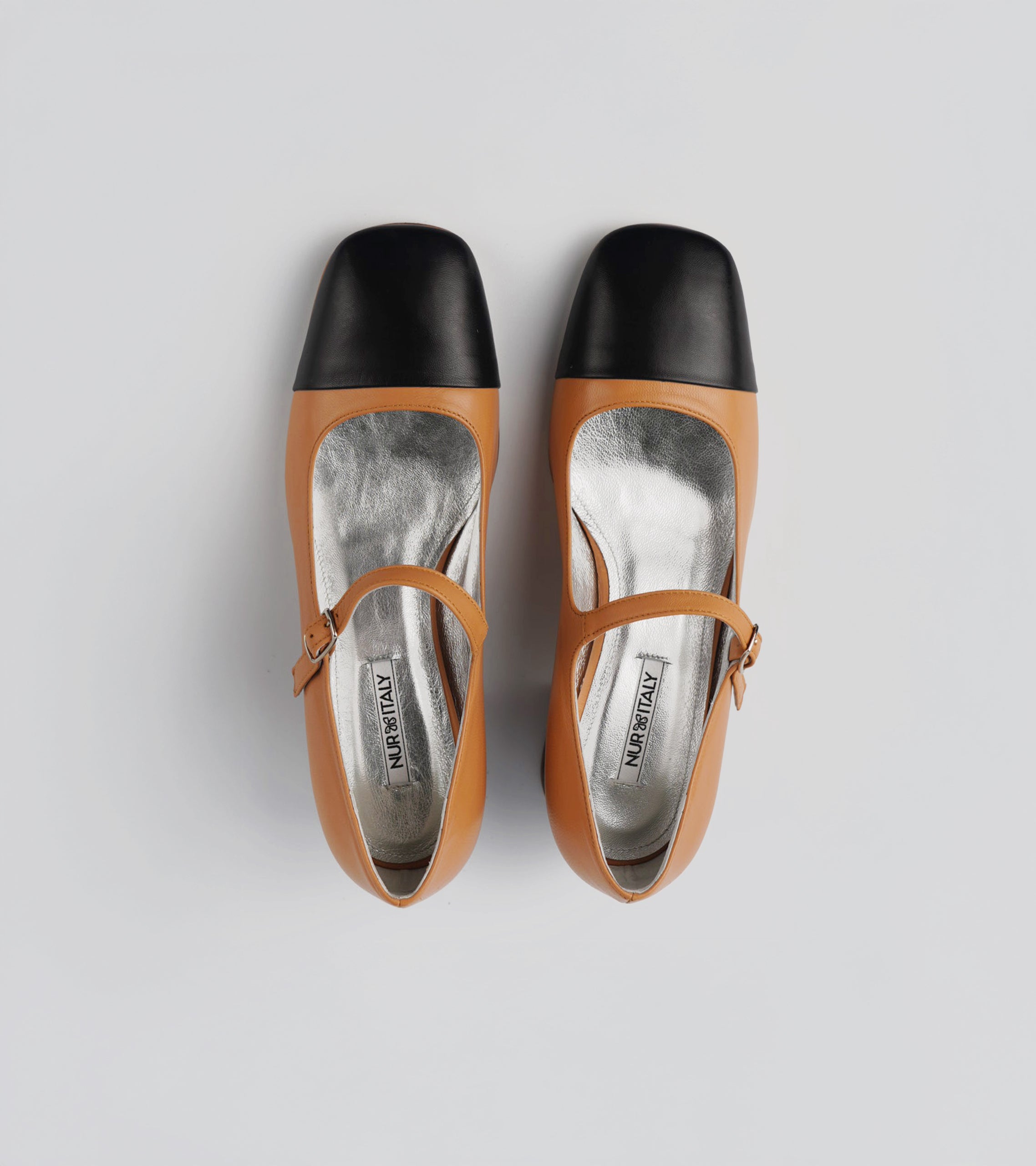 Pair of tan high-heeled shoes with black soles on a white background #color_palermo tan milano black