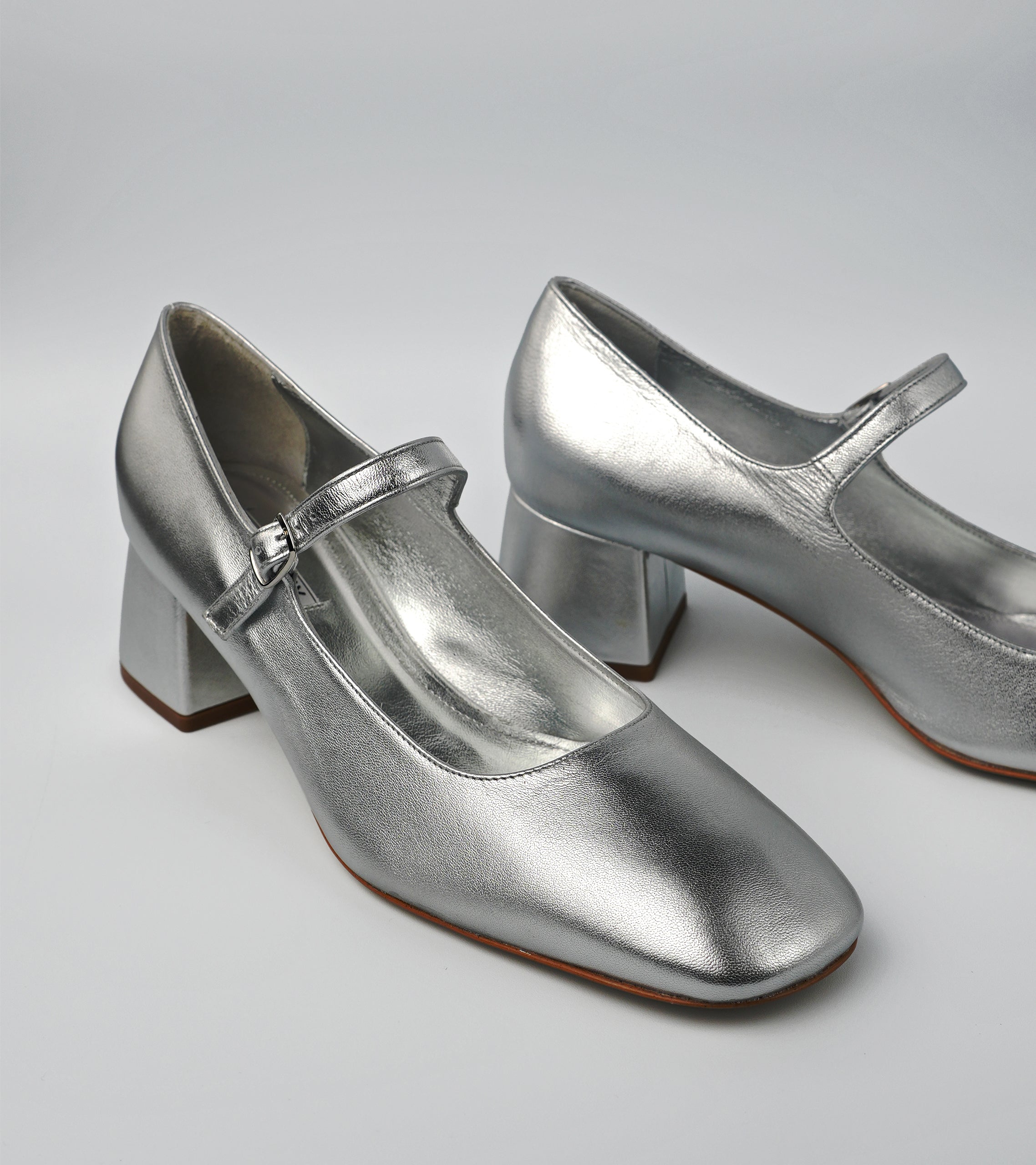 Silver metallic shoes with a block heel on a light gray background #color_napoli silver
