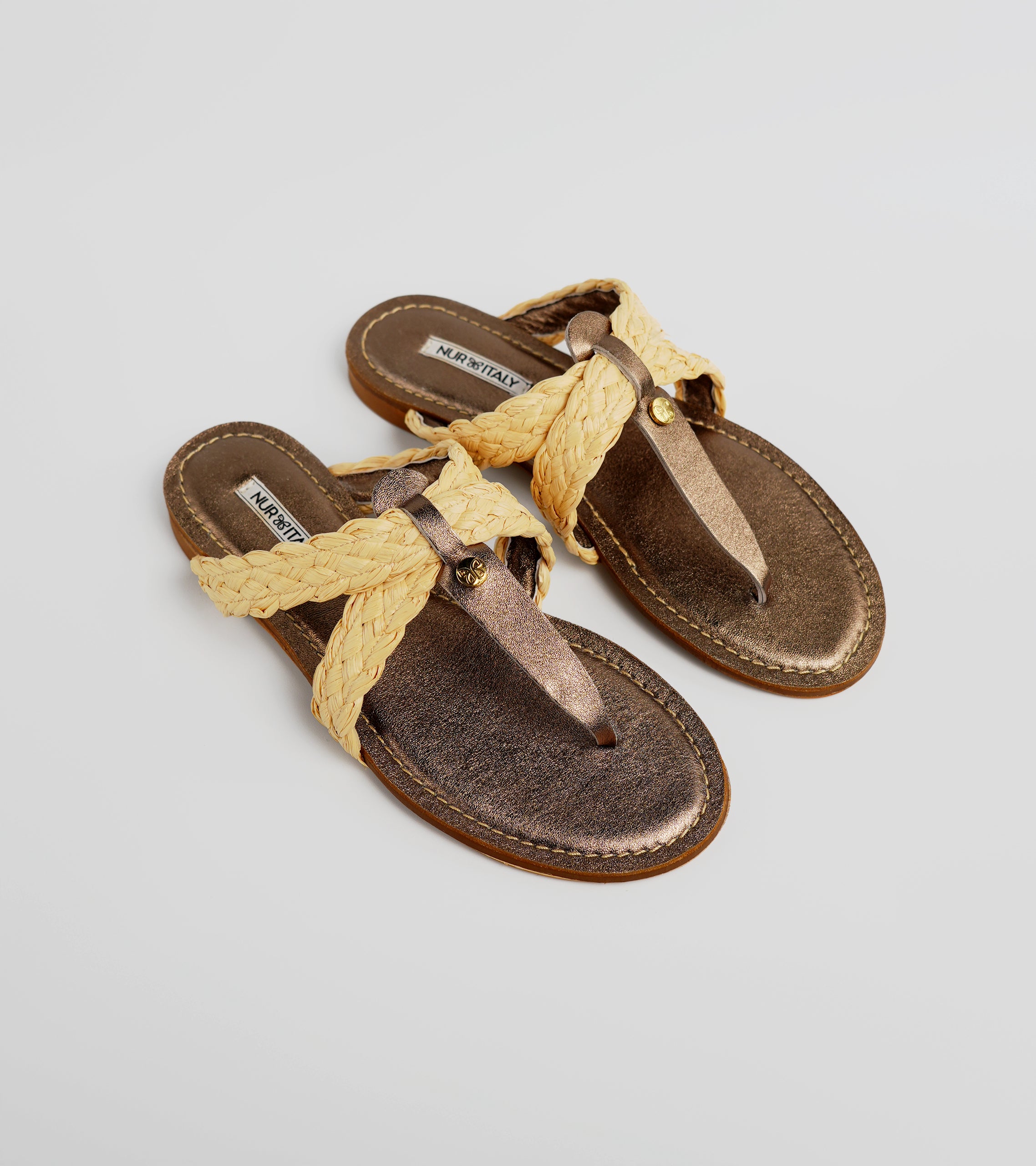 Pair of brown sandals with yellow braided straps on a light gray background #color_siena bronze