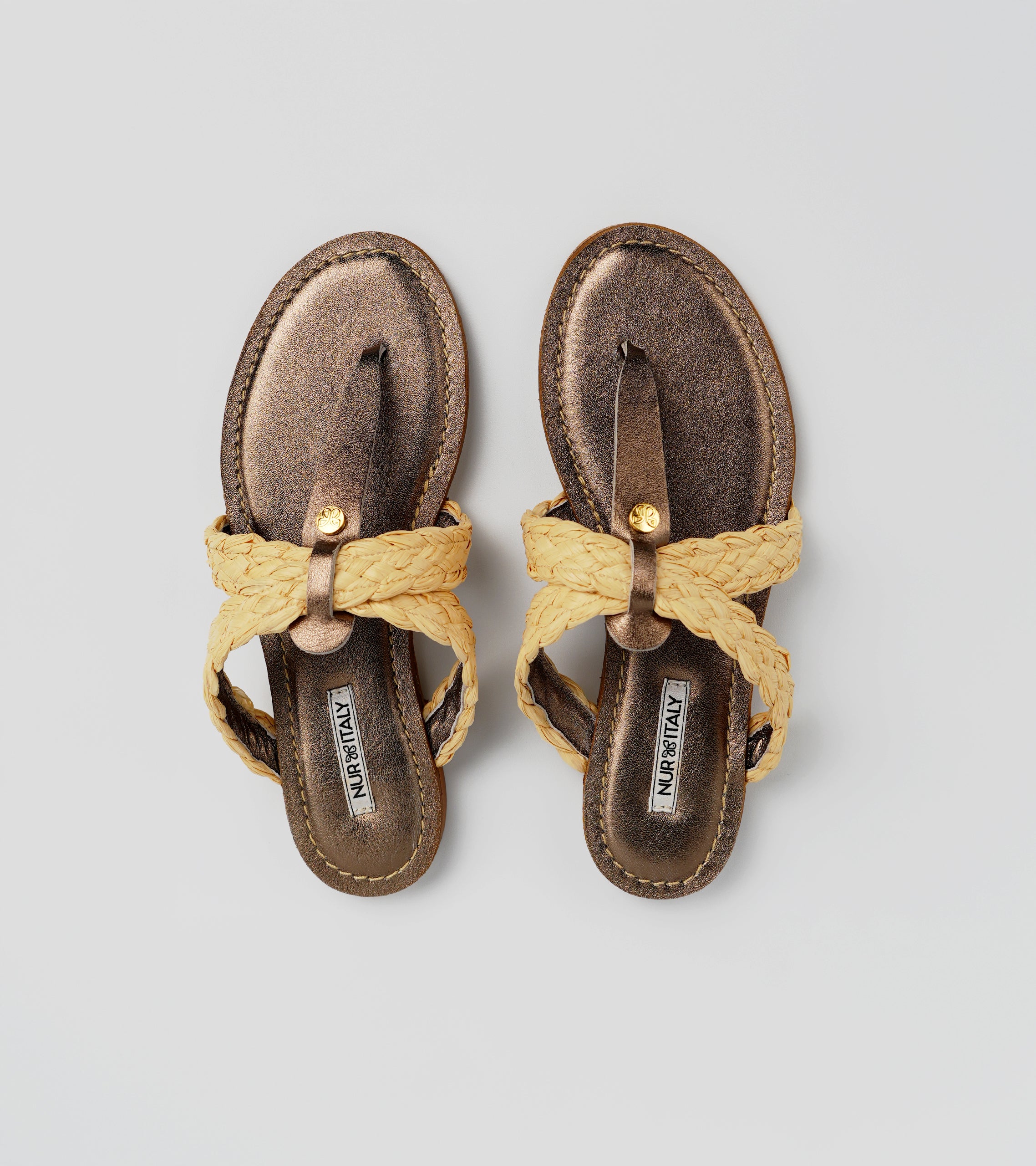 Pair of brown sandals with yellow straps on a light gray background #color_siena bronze