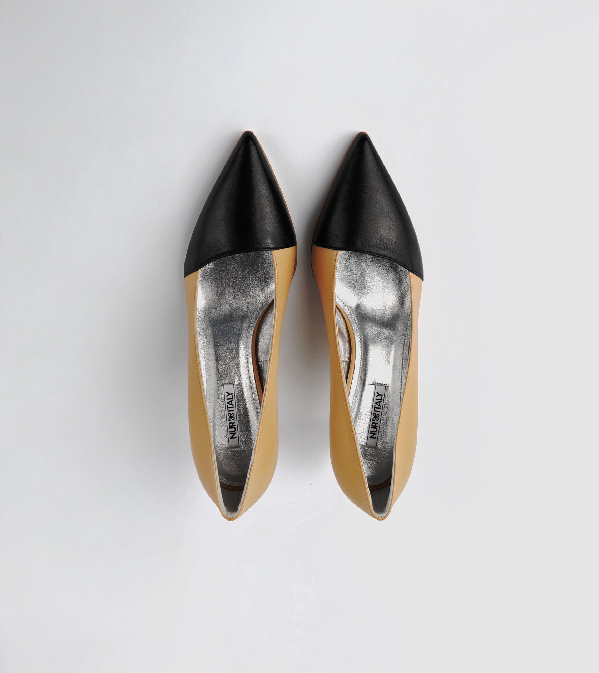 Black pointed-toe shoes with beige soles on a light gray background #color_grosetto nude