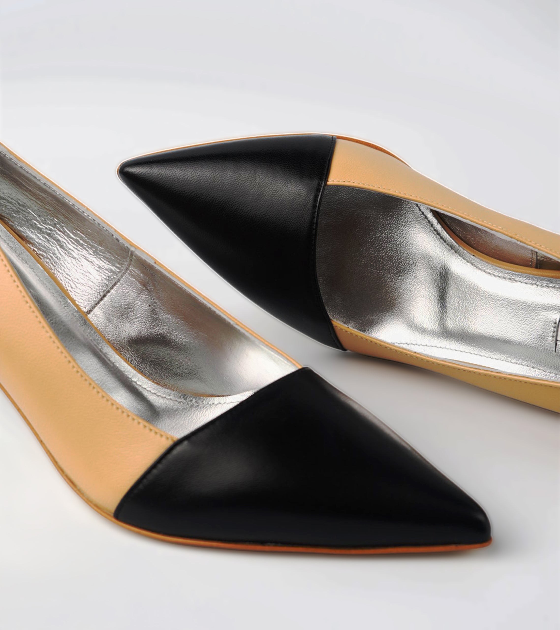 Pair of high-heeled shoes with black, beige, and silver color scheme on a light gray background #color_grosetto nude
