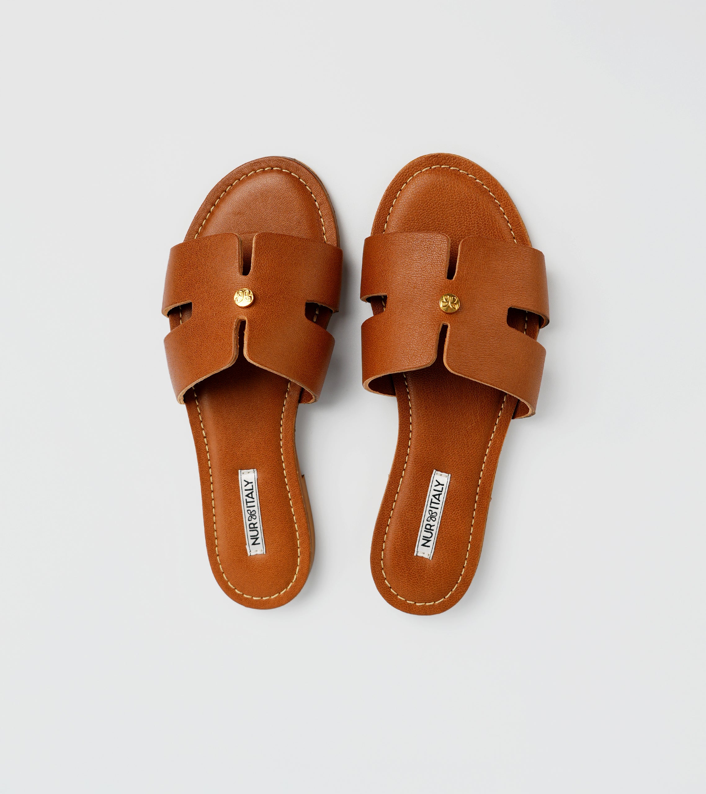 Pair of brown sandals on a light gray background #color_palermo tan