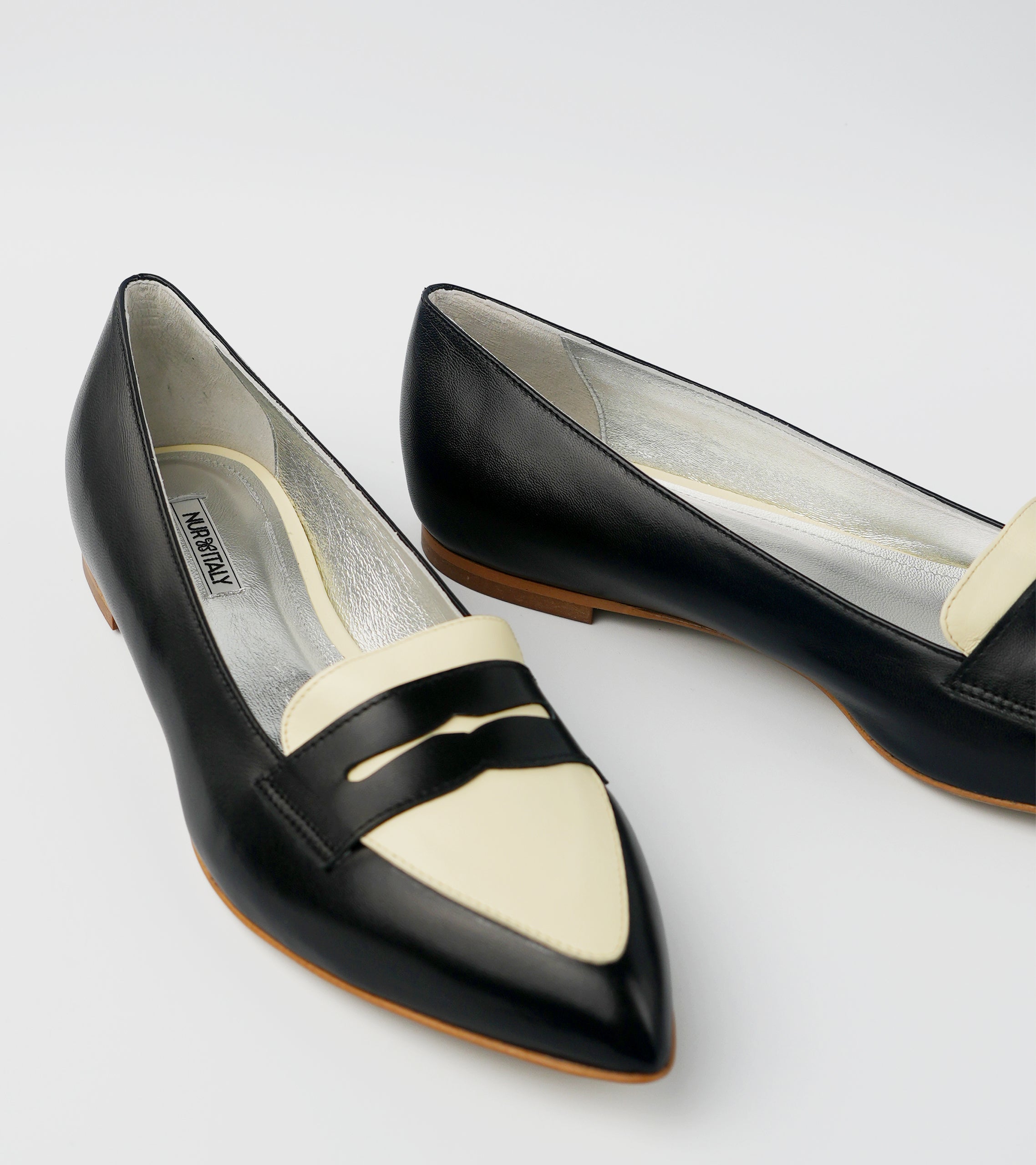 Black and white pointed-toe shoes on a light gray background #color_milano black amalfi white