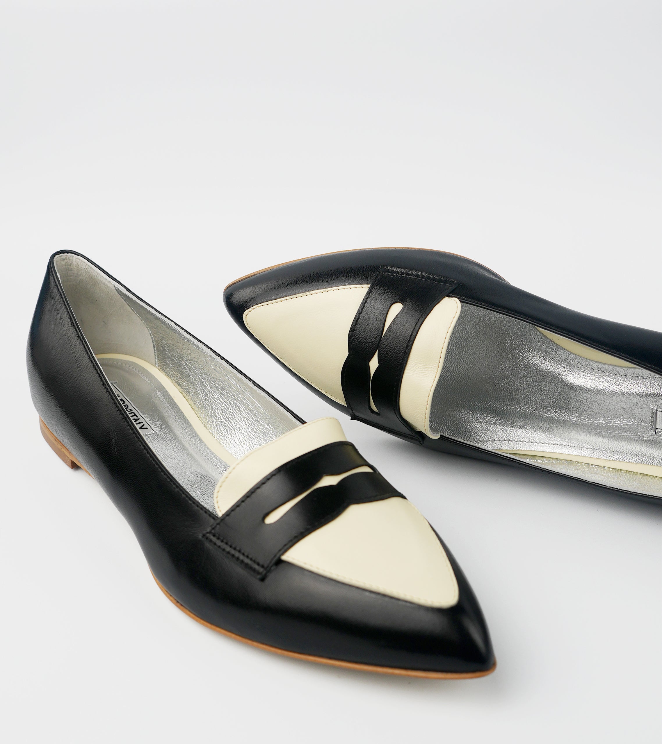 Black and white pointed-toe flats on a light gray background #color_milano black amalfi white