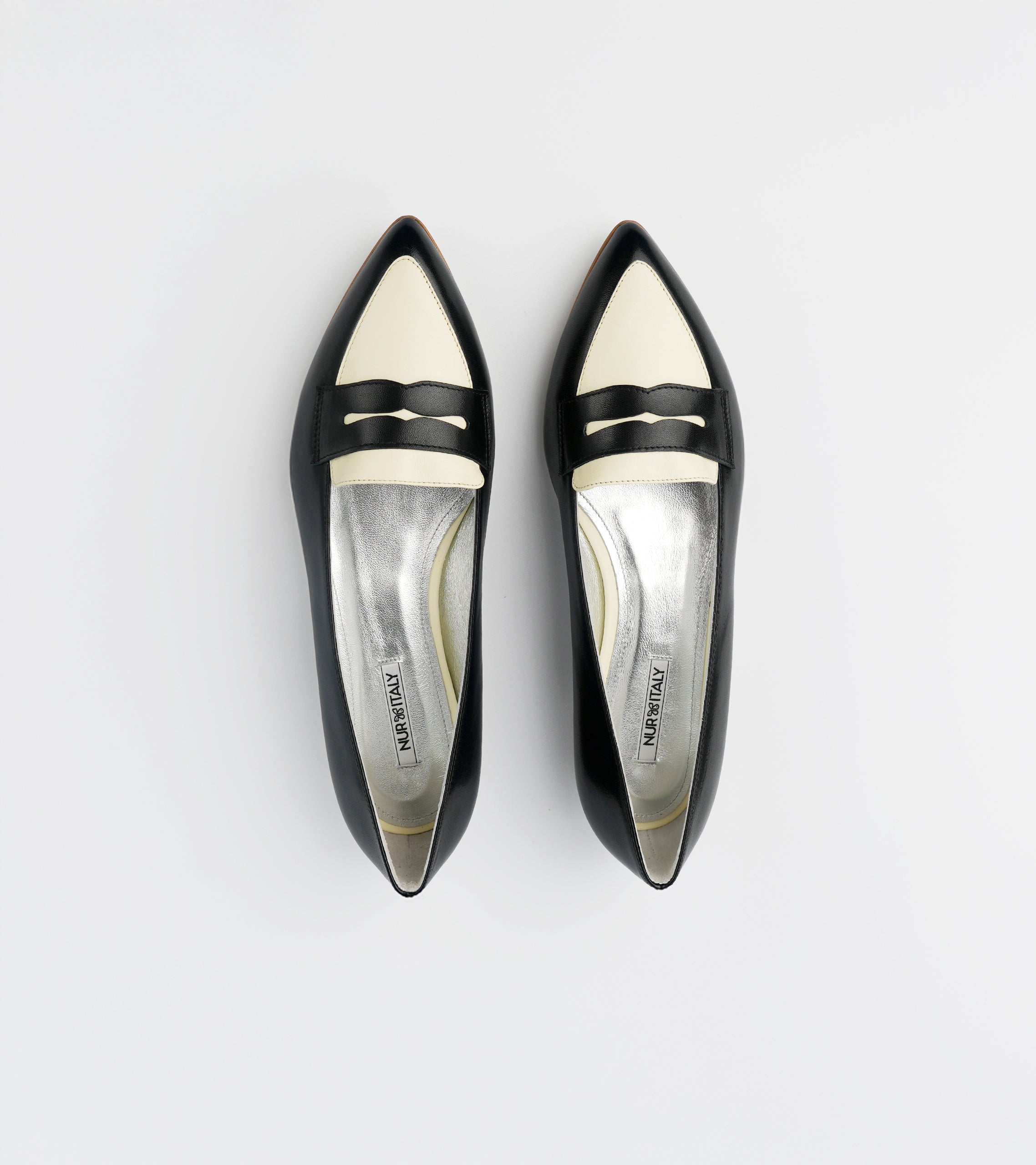 Pair of black and white pointed-toe shoes on a light gray background #color_milano black amalfi white