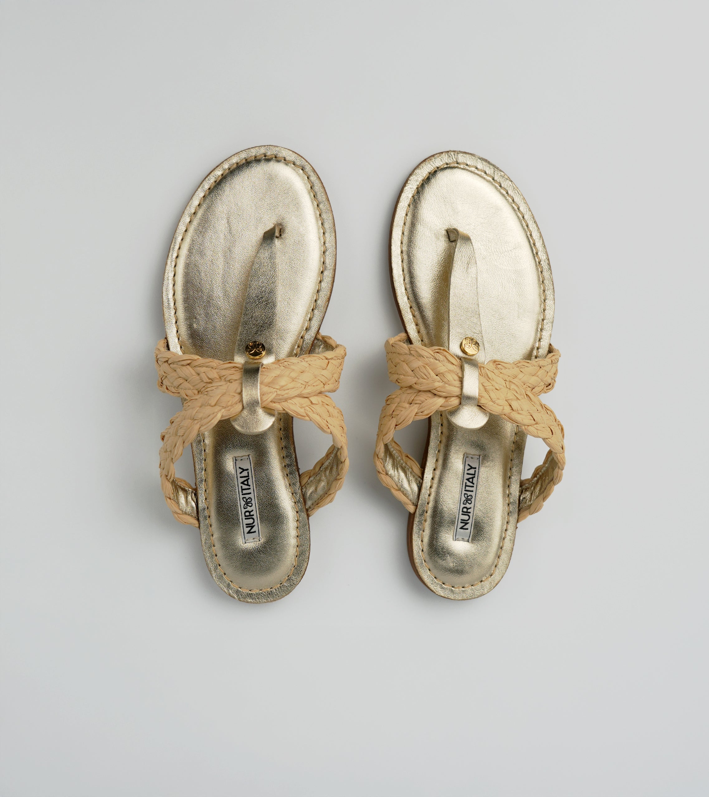 Pair of gold sandals with bow details on a gray background #color_venezia gold