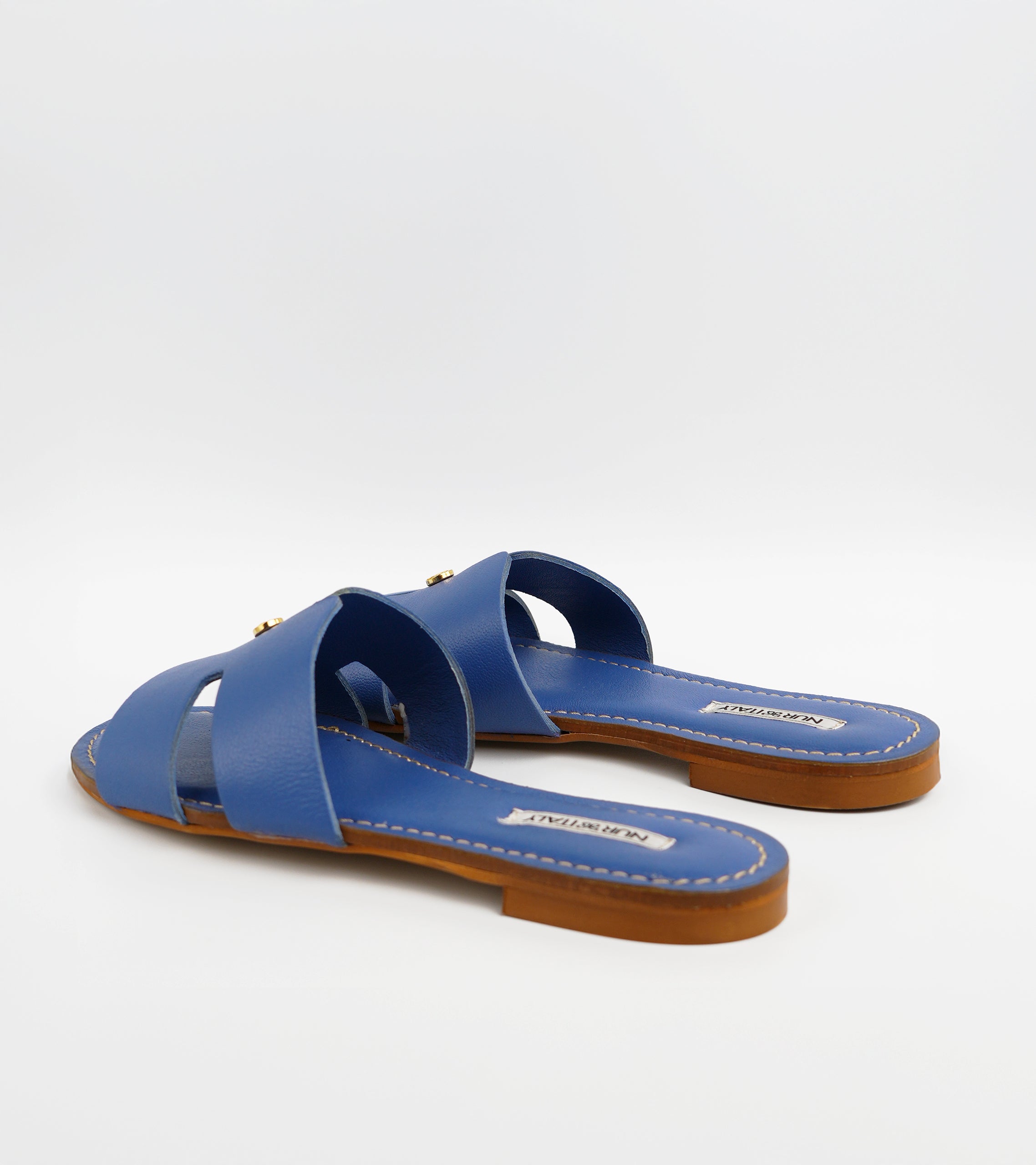 Pair of blue sandals with brown soles on a white background #color_capri blue